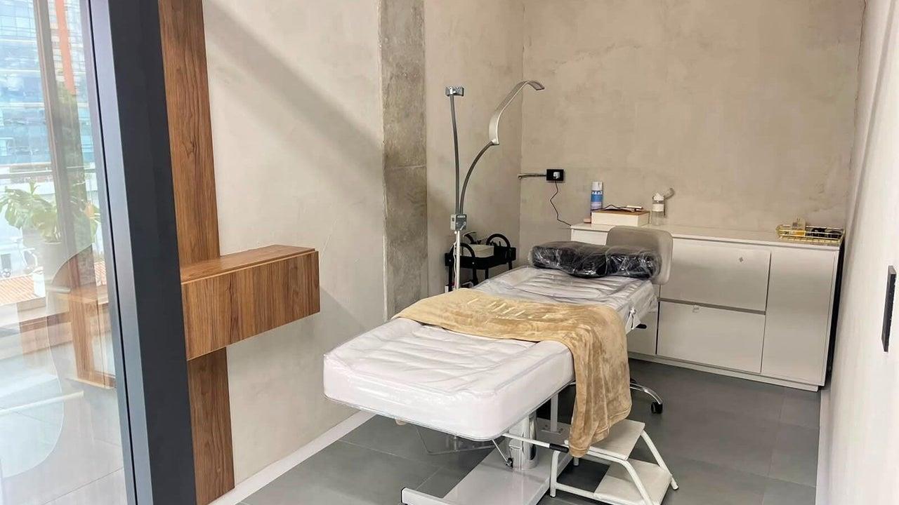 Sala de tratamientos con camilla y luz tenue